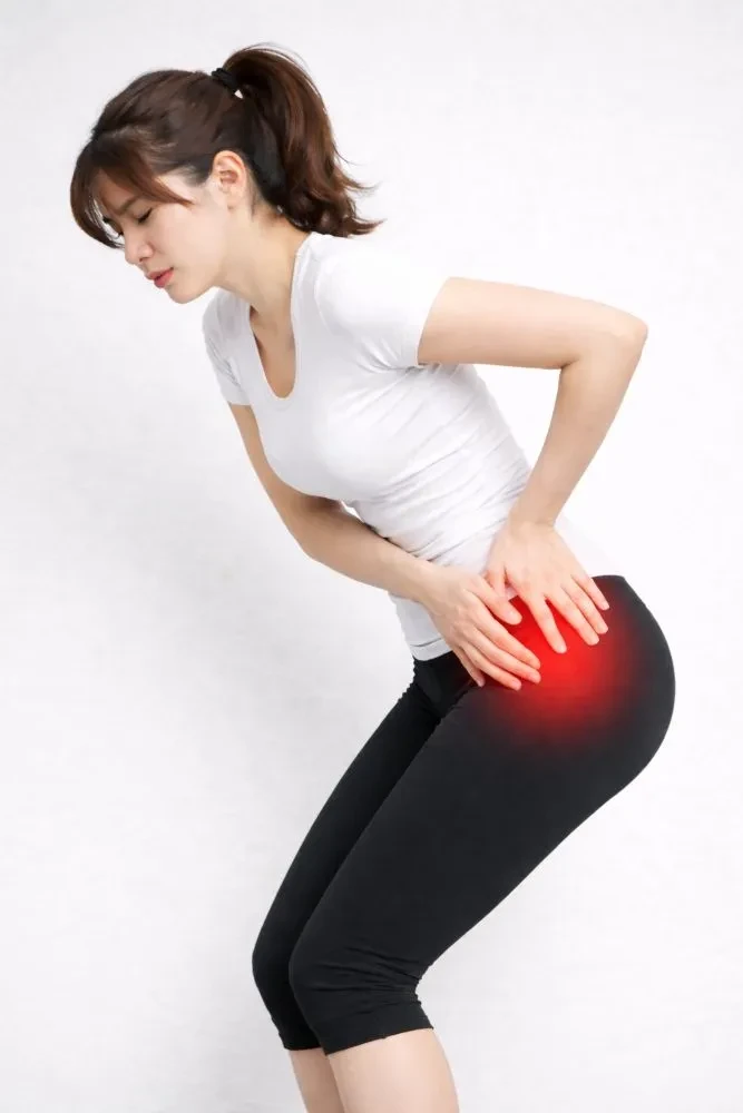 股関節まわりを押さえる女性