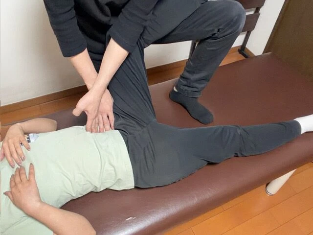 股関節まわりの整体施術を受ける女性